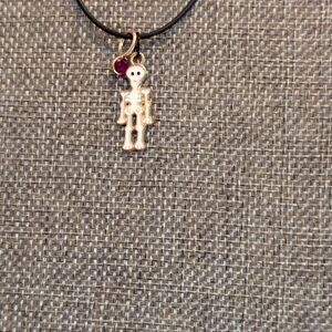 White Skeleton Pendant Necklace With Red Charm On A Black Cord